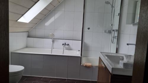 een badkamer met een bad, een wastafel en een toilet bij Hotel Lohauser Hof in Düsseldorf