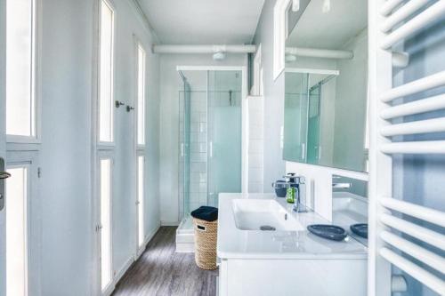 une salle de bain blanche avec un lavabo et un miroir dans l'établissement Elégant T5 avec Clim & Terrasse, à Montpellier