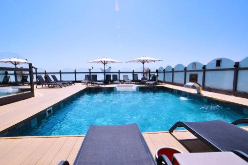 伊斯坦堡的住宿－維琴察酒店，一座大楼内的游泳池,配有椅子和遮阳伞