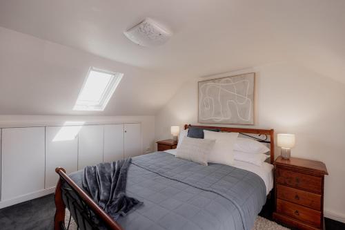 霍巴特Stay steps from Salamanca in historical cottage的一间带床、两盏灯和一扇窗户的卧室