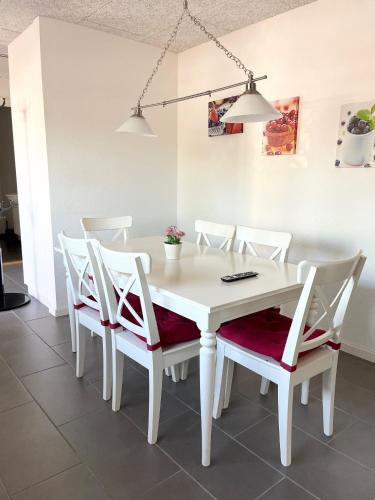 a white dining room table and chairs with lights at Biersted Kro in Åbybro