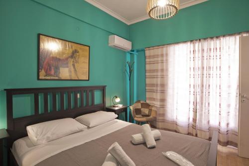 een slaapkamer met blauwe muren en een bed met witte kussens bij Sunny View in Koukaki in Athene