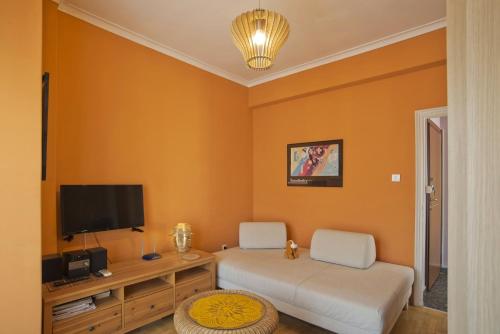 een woonkamer met 2 witte stoelen en een flatscreen-tv bij Sunny View in Koukaki in Athene