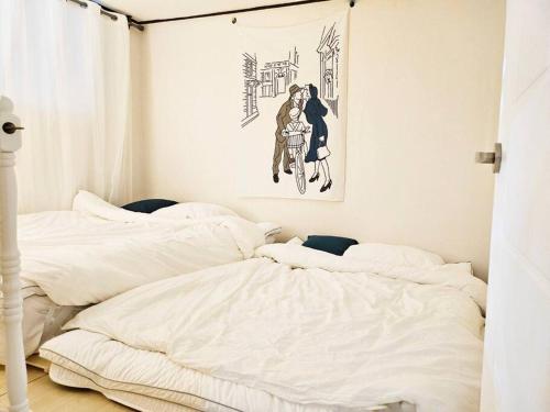 a bedroom with two beds and a picture on the wall at open특가 komorebi 강남10분 홍대 명동 잠실 2호선 낙성대 빔 감성숙소 in Seoul