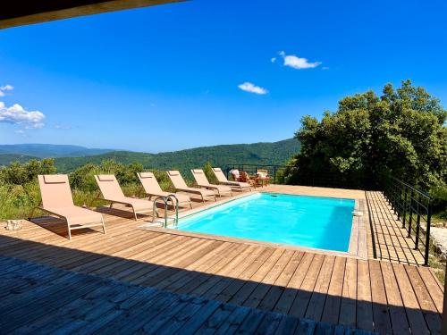 - une piscine avec des chaises longues à côté d'une terrasse en bois dans l'établissement Villa Rose, à Solliès-Toucas