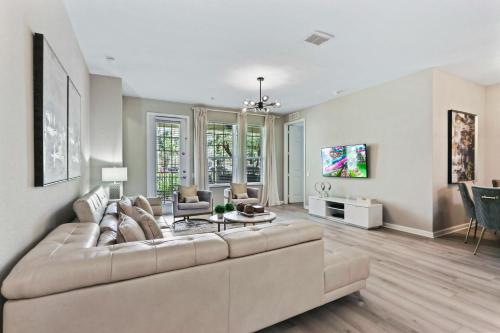 a living room with a large couch and a tv at 4804 Cayview Ave #105 in Orlando