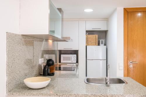 Ca lEudald 2 Ideal para parejas con terraza في بيسالو: مطبخ مع مغسلة وثلاجة بيضاء