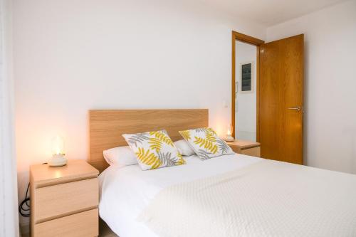 een slaapkamer met een wit bed met 2 kussens bij Ca lEudald 2 Ideal para parejas con terraza in Besalú