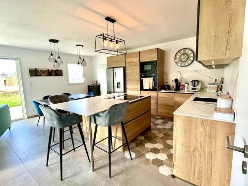 une cuisine avec une table et quelques chaises dans l'établissement Terre Marine - Maison neuve, à Erdeven