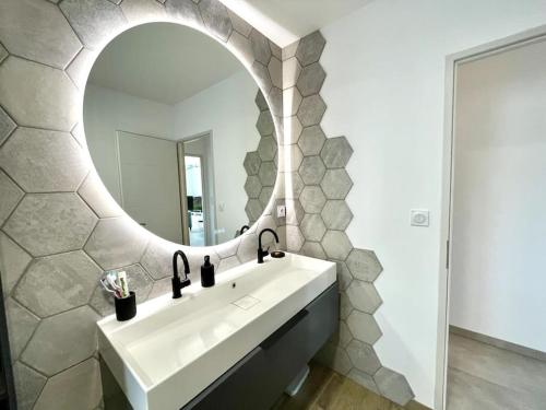 a bathroom with a white sink and a mirror at Terre Marine - Maison neuve in Erdeven