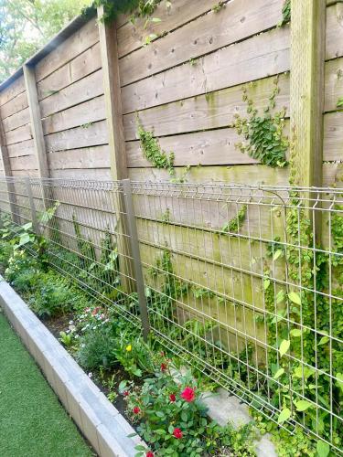 a fence with flowers in a garden at 湘南片瀬HOME in Fujisawa