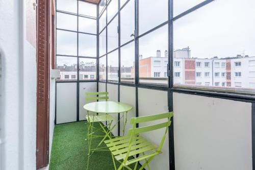 une table et deux chaises dans une pièce avec des fenêtres dans l'établissement Pretty 2 rooms in the city center, à Annecy