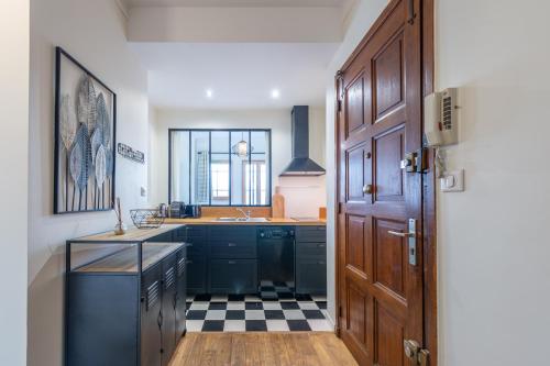 een keuken met zwarte kasten en een geruite vloer bij Pretty 2 rooms in the city center in Annecy