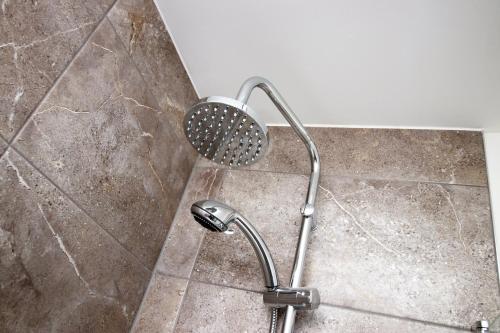a shower with a shower head in a bathroom at Boutique One BR | Free Parking in Taunton