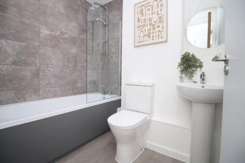 a white bathroom with a toilet and a sink at Boutique One BR | Free Parking in Taunton