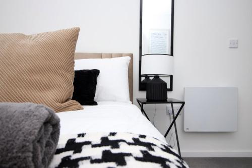 a bedroom with a bed and a lamp on a table at Boutique One BR | Free Parking in Taunton