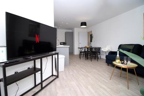 a living room with a large flat screen tv at Boutique One BR | Free Parking in Taunton