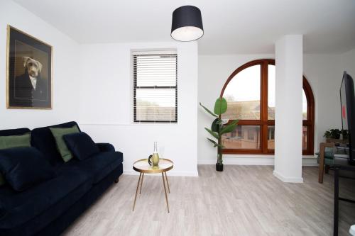 a living room with a blue couch and a table at Boutique One BR | Free Parking in Taunton