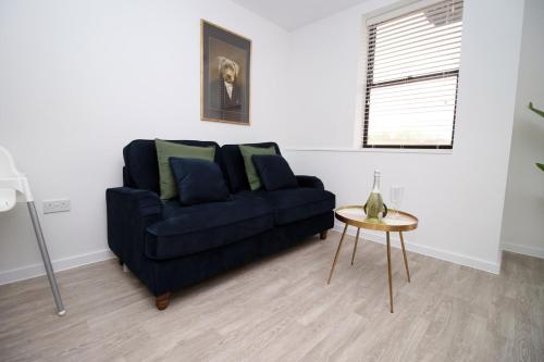 a living room with a blue couch and a table at Boutique One BR | Free Parking in Taunton