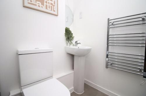 a white bathroom with a toilet and a sink at Boutique One BR | Free Parking in Taunton