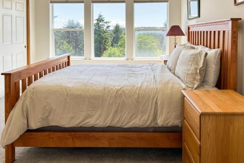 1 dormitorio con 1 cama grande con sábanas y almohadas blancas en La Cana Street Leisure - Main Home & In-Law suite, en Coupeville