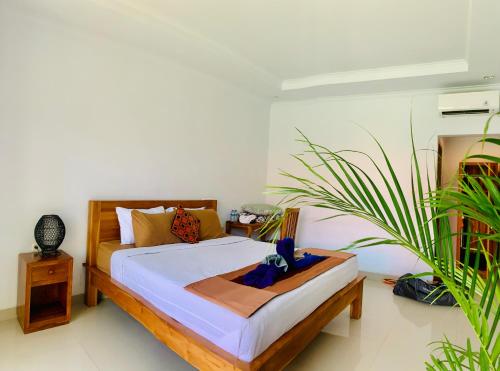 a bedroom with a bed and a plant at Bali intan Canggu in Canggu