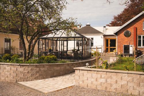 a garden with a gazebo in front of a house at Två Systrar B&B in Skurup