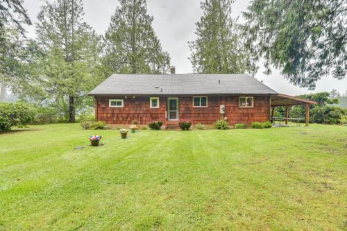 a small house in a field with a grass yard at Waterfront Grapeview Escape with Boat Dock and Views! in Grapeview
