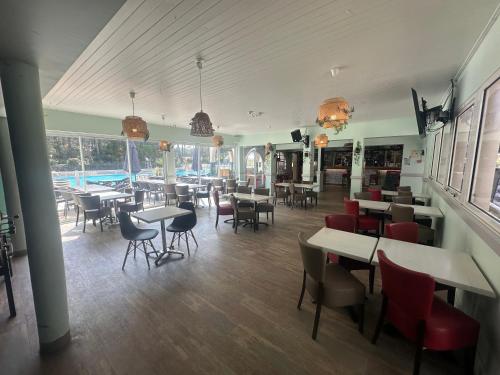 サン・ジャン・ド・モンにあるcamping 4 Etoiles A ST JEANS-DE-MONTS Mobil home 4à6 persのテーブルと椅子のあるレストラン、プールを提供しています。