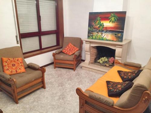 a living room with two chairs and a fireplace at 2 bedrooms apartement at Espinho 600 m away from the beach with furnished terrace in Espinho