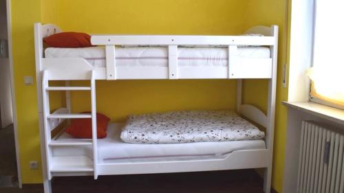 two bunk beds in a room with a yellow wall at FeWo "Hündleblick" Oberstaufen/Steibis in Oberstaufen