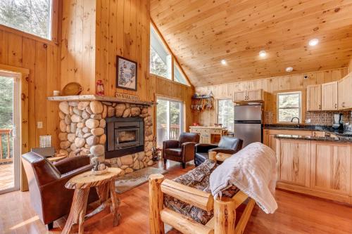 a kitchen and living room with a stone fireplace at Tranquil Thornton Cabin Deck, Views and Game Room! in Thornton