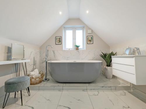 a bathroom with a large tub and a sink at Roseland Penthouse - Arundel in Arundel