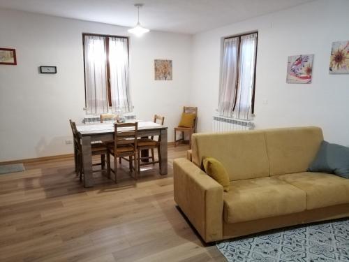 uma sala de estar com um sofá e uma mesa em A casa di Matisse - appartamento vacanze em Urbino