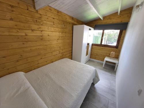 1 dormitorio con 1 cama en una habitación de madera en Preciosa cabaña en Guía de Isora