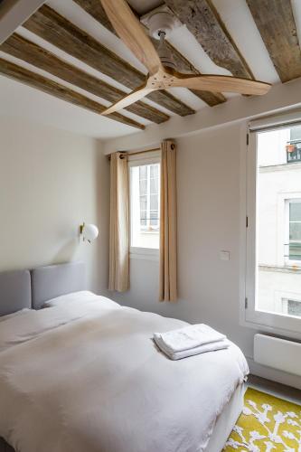 une chambre avec un lit et deux fenêtres dans l'établissement Heart of le Marais, à Paris