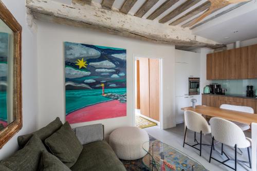 un salon avec un canapé et un tableau au mur dans l'établissement Heart of le Marais, à Paris