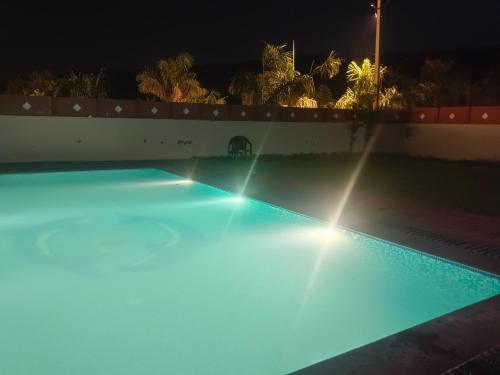 una piscina por la noche con luces azules en Hotel Mewad Haveli Pushkar en Pushkar