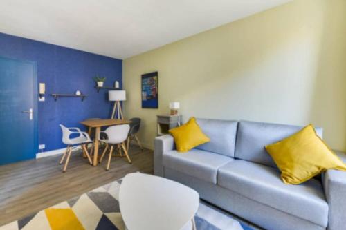 un salon avec un canapé et une table dans l'établissement Suite L'Ambassade - Second Lodge - Hyper Centre, à Rennes