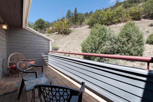 a porch with two chairs and a view of a hill at Pine Acres - Unit 115 in Durango