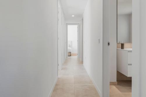 a hallway with white walls and a long white hallway at Casa Graceias in Estepona