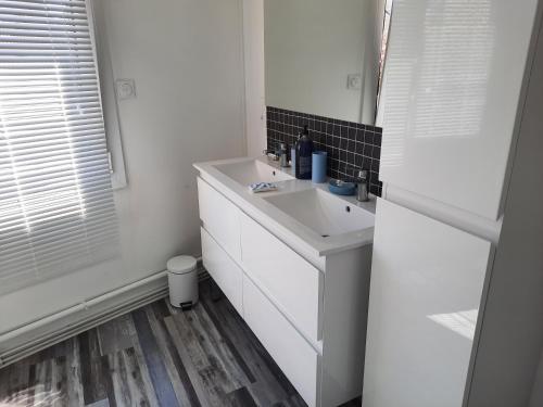 une salle de bain blanche avec un lavabo et un miroir dans l'établissement appartement T3 quartier ARAGO, à Les Sables-dʼOlonne