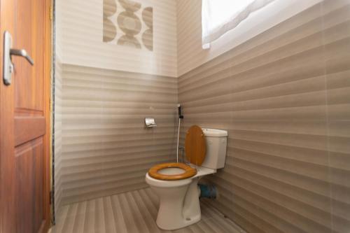 達累斯薩拉姆的住宿－Getaway Experience Villa.，一间带卫生间和木座椅的浴室
