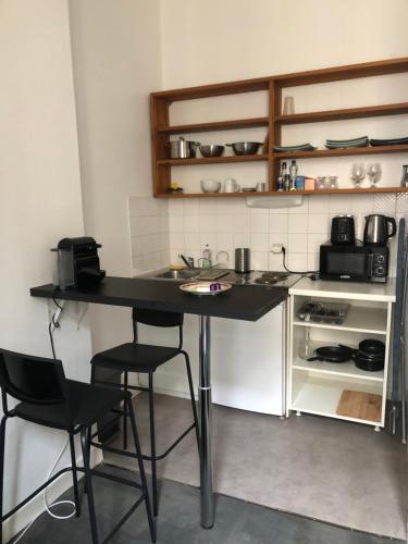 - une cuisine avec une table et deux chaises dans l'établissement studio de 30 m2 dans le triangle d'or de Bordeaux, à Bordeaux