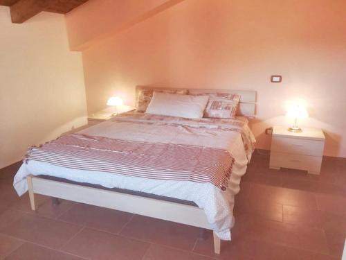 um quarto com uma cama e 2 candeeiros nas mesas em 2 bedrooms apartement with furnished balcony and wifi at Casalvecchio Siculo 6 km away from the beach em Casalvecchio Siculo