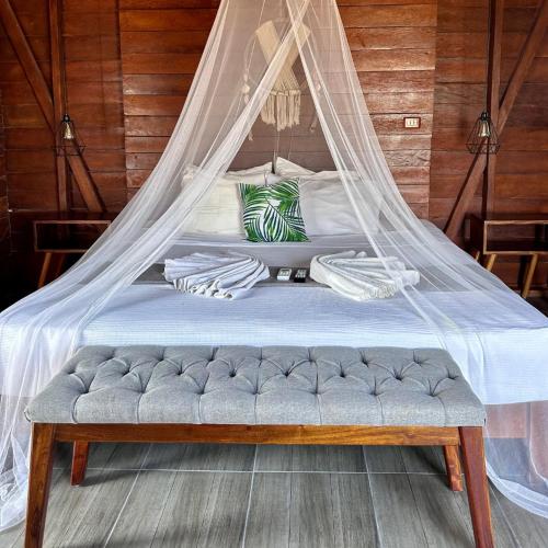 a bed with a mosquito net on top of it at Ecoco Holbox - EcoChic - Cabañas de Madera - Holbox Retreat in Holbox Island
