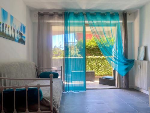 um quarto com uma cama e uma porta de vidro deslizante em Studio Jardin Fleuris Parking em Nice