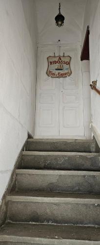 a set of stairs with a white door with a sign on it at "A Ridosso" sul mare nel cuore del paese in Le Grazie