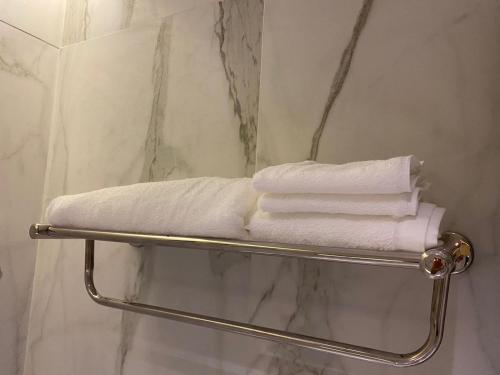 - un porte-serviettes dans la salle de bains pourvue de serviettes blanches dans l'établissement Jardin an, à Abha
