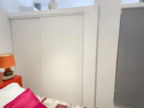Schlafzimmer mit weißen Schränken und einem Bett in der Unterkunft Appartement d'une chambre avec terrasse amenagee a Prats de Mollo la Preste in Prats-de-Mollo-la-Preste